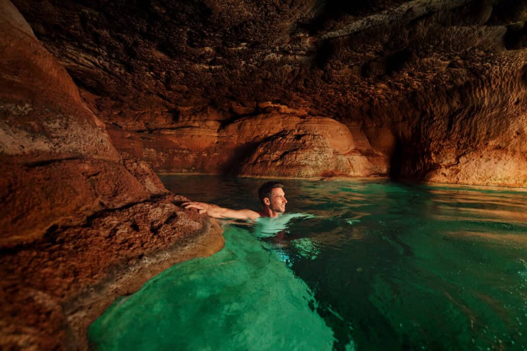 Jared Dillingham swimming in a cave along Fossil Creek.