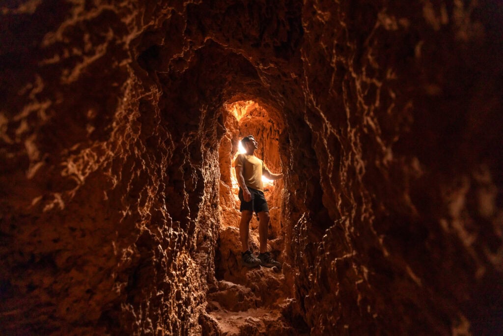 Climbing through one of the tunnels at Mooney Falls