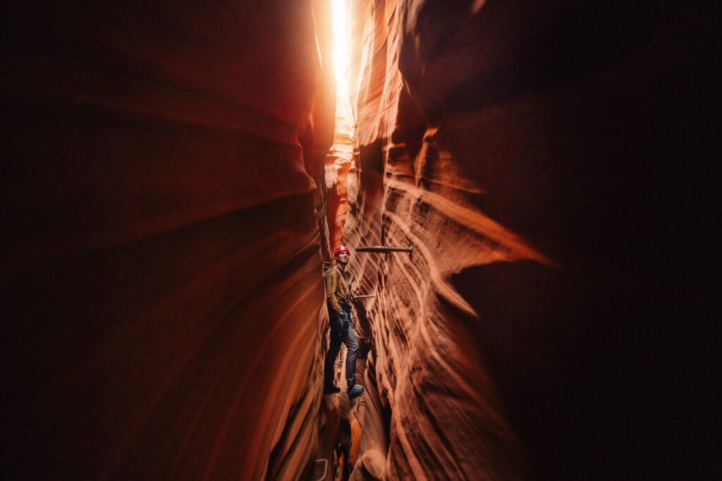 Rock climbing through a narrow part of Antelope Canyon