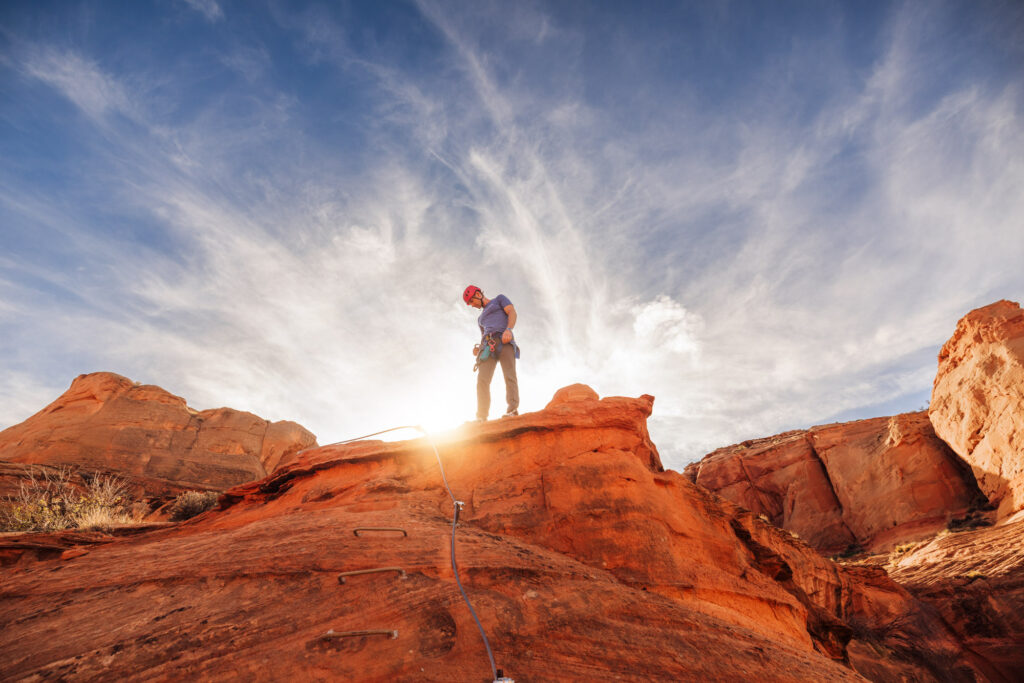A tourist rock climbing at Antelope Canyon
