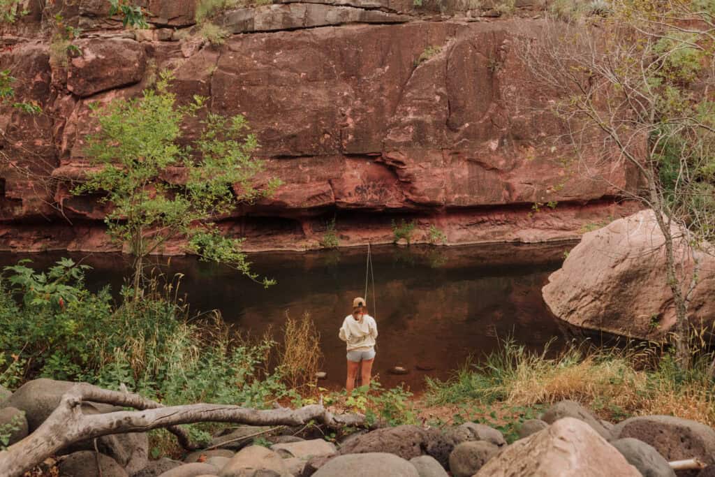 A woman fishing under Midgley Bridge, along Oak Creek in Sedona